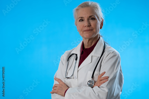 Φωτογραφία Portrait of mature woman doctor thinking, wondering, listening isolated on blue background with copy space