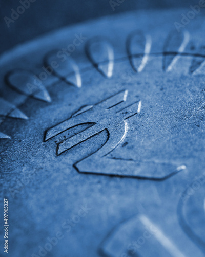 Translation: rupee. Fragment of Indian 10 rupee coin with the sign of the national currency close-up. Blue tinted illustration. Economy and finance of India. Vertical stories. Macro