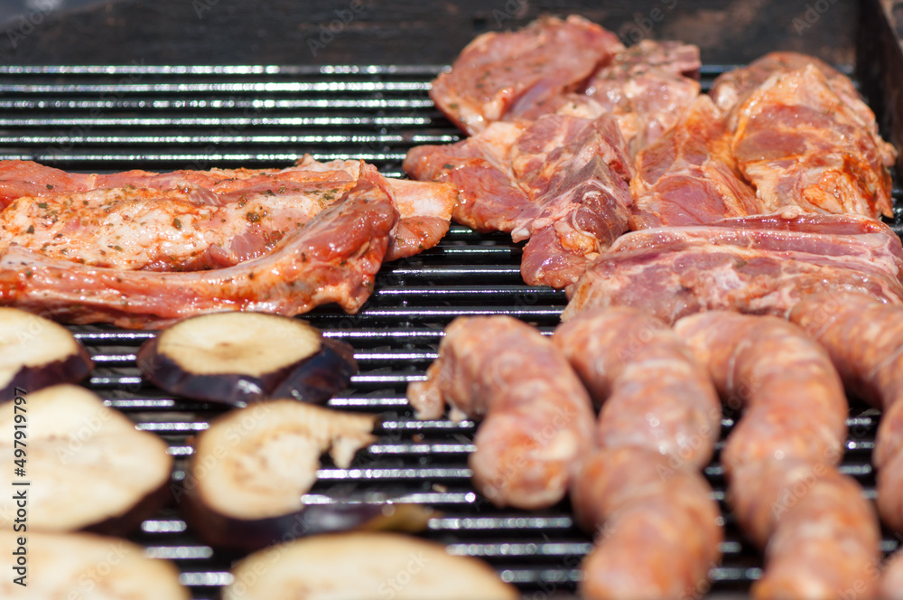 barbecue steaks, sausages, and eggplants (mostly raw)