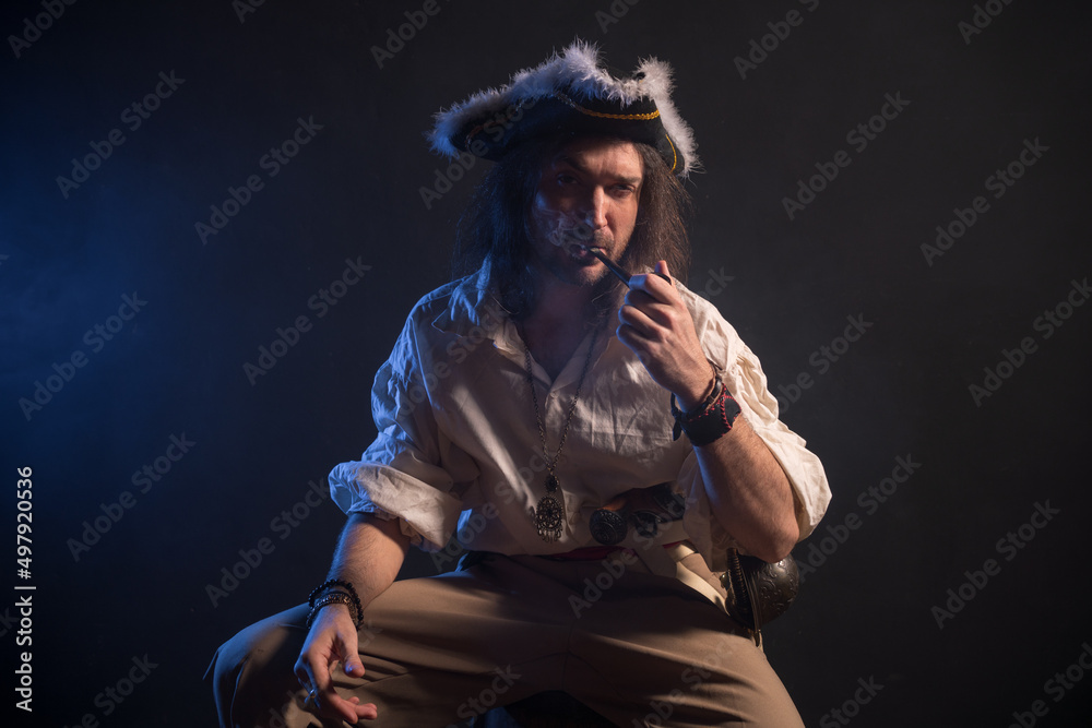 Fototapeta premium Pirate filibuster sea robber in suit with gun and saber. Concept photo