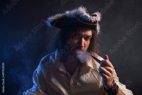 Pirate filibuster sea robber in suit with gun and saber. Concept photo