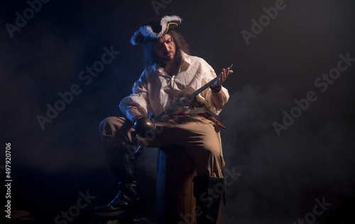 Pirate filibuster sea robber in suit with gun and saber. Concept photo
