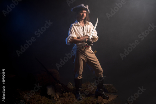 Pirate filibuster sea robber in suit with gun and saber. Concept photo