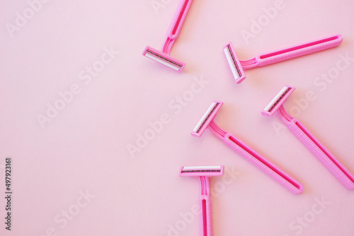 Disposable female razor on a pink background. A tool to remove hair from the skin. Female depilation and hygiene. Body care. Top view, copy space, stylish magazine concept photo