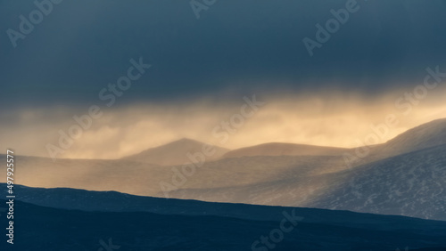 Epic Winter landscape image of view along Rannoch Moor during heavy rainfall giving misty look to the scene
