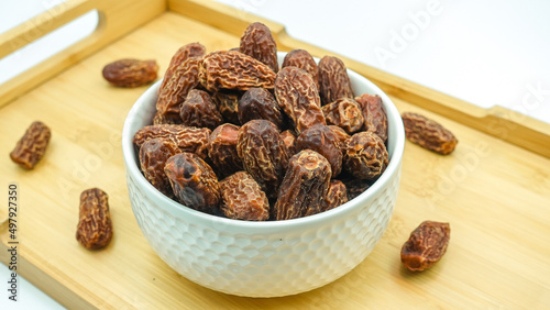 Dates also known as Khajur. Tasty dry dates isolated on white background. Arabic food that muslims eat during Ramadan. Super dietery food.  photo