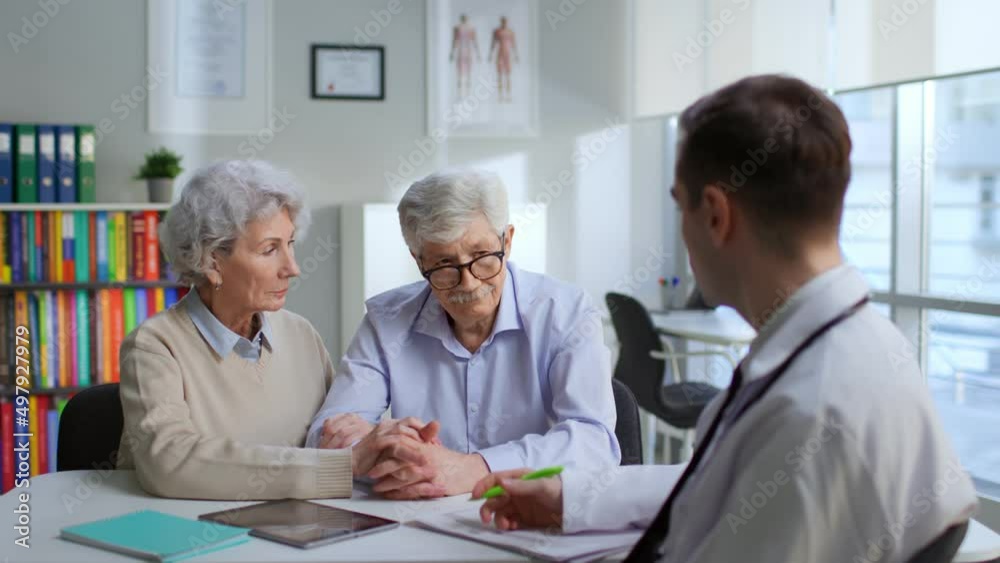 Upset aged couple consult oncologist in modern medical center Upset aged couple consult oncologist in modern medical center