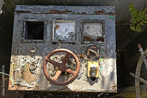 Old decayed control panel with steering wheel and knobs