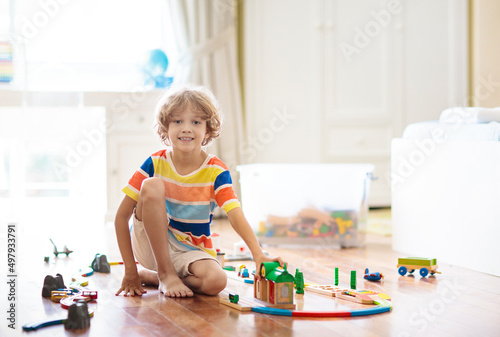 Kids play wooden railway. Child with toy train.