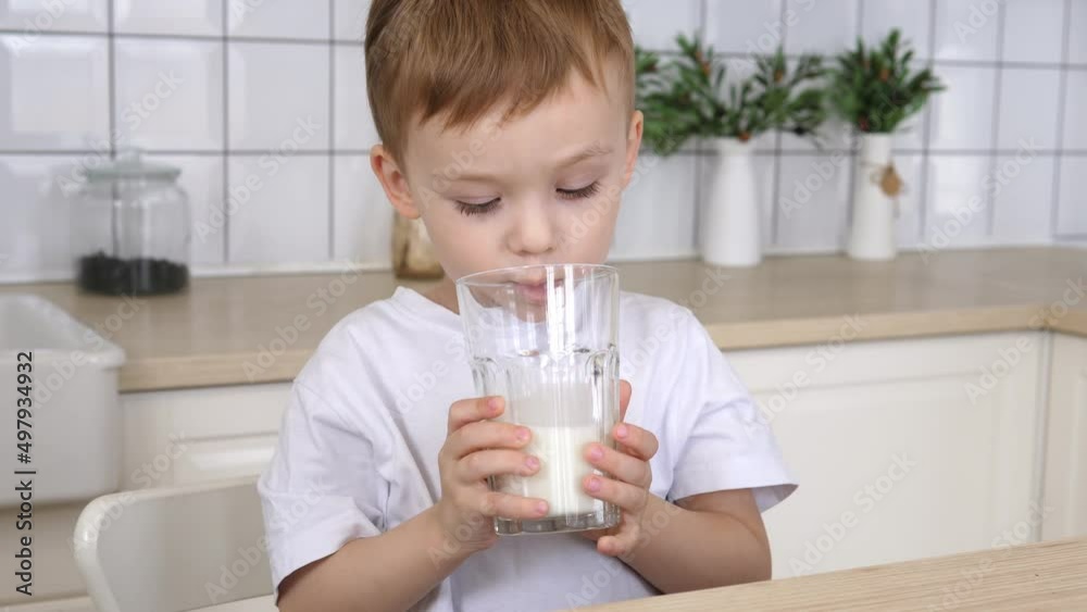 Little boy drinks milk. Happy blue-eyed child has breakfast. Healthy food child having breakfast child dream concept. Little boy drinks milk. Happy blue-eyed child has breakfast. Healthy food child having breakfast child dream concept.