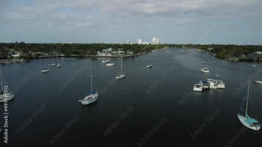 Aerial view of sailboats in the harbor and luxury real estate in the background Aerial view of sailboats in the harbor and luxury real estate in the background