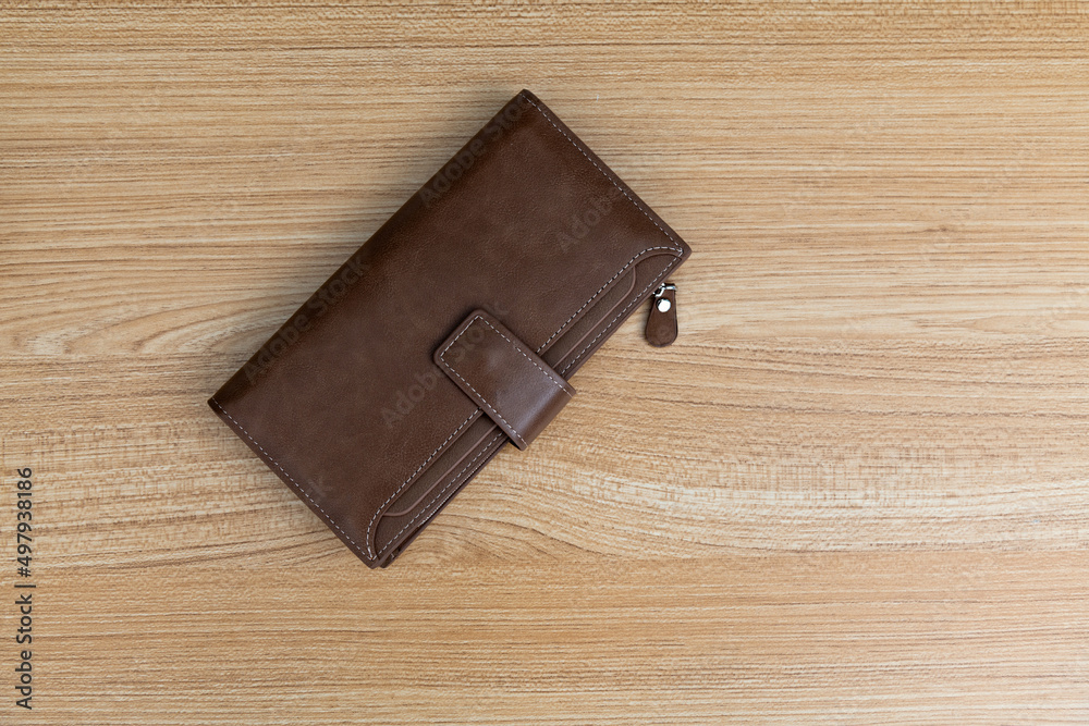 Brown leather wallet on wooden table Brown leather wallet on wooden table