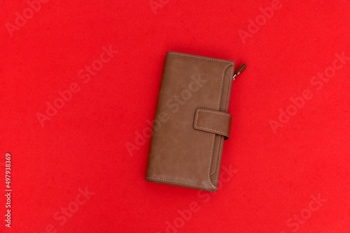 Brown leather wallet on red background