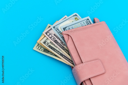 Wallet with dollars on blue background