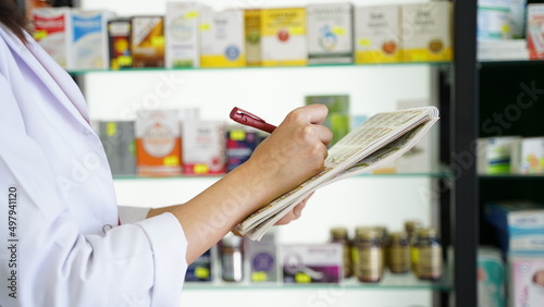 Female Pharmacist Noting Medicines In Pharmacy