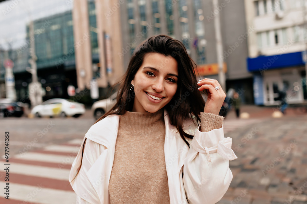 Outdoor portrait of charming pretty woman with dark hair and wonderful smile is walking down the street Outdoor portrait of charming pretty woman with dark hair and wonderful smile is walking down the street