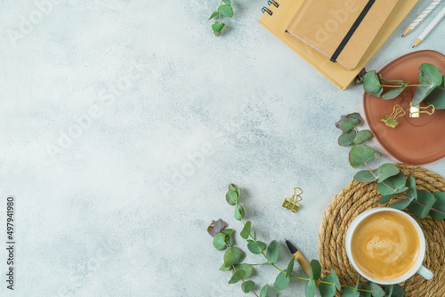 Modern desk with eco friendly stationary and eucalyptus branches. Sustainable lifestyle concept. Top view, flat lay with copy space photo