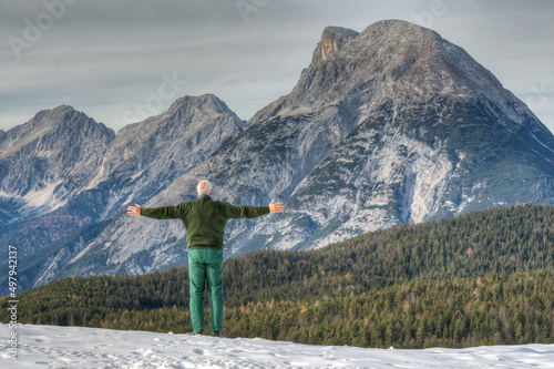 A mountaineer stands in front of the impressive backdrop of the Mount Hohe Munde and would like to embrace this mountain with its unusual shape. photo