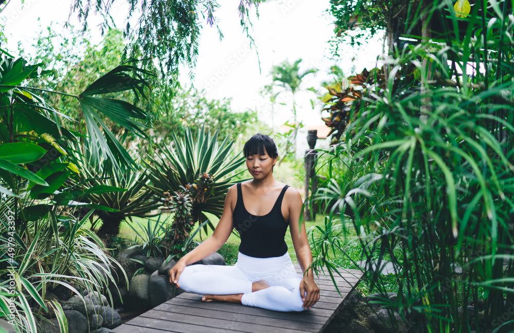 Asian girl practicing yoga in tropical garden Asian girl practicing yoga in tropical garden