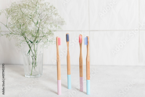 Pink and blue four bamboo toothbrushes on a white background in bathroom. Eco friendly, zero waste, plastic free concept.