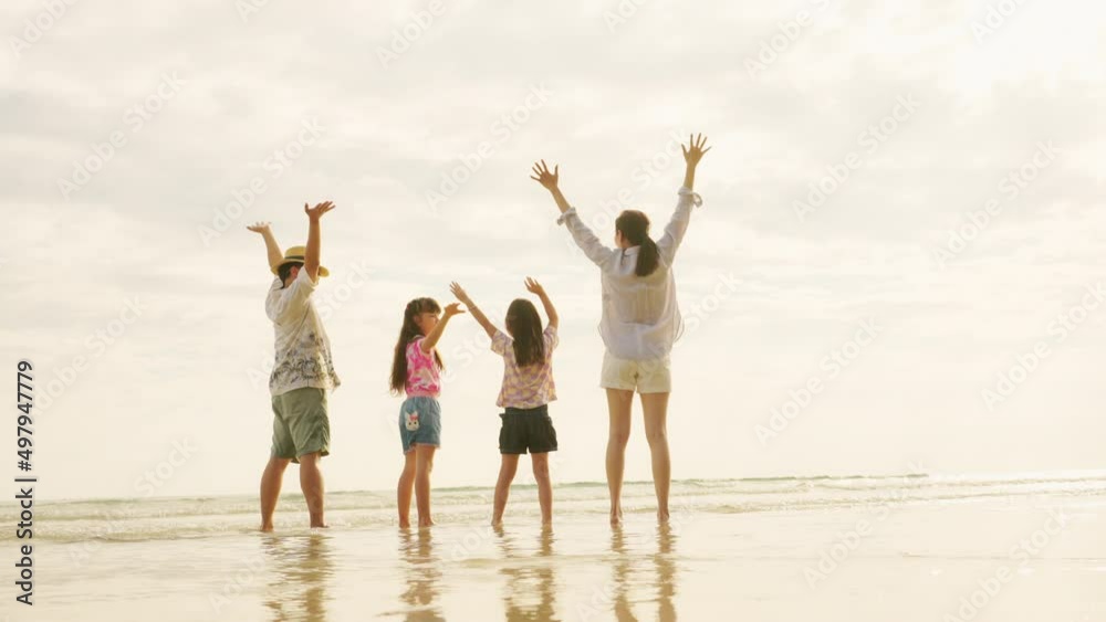 Happy Asian family father and mother with two little daughter walking and playing together on the beach at summer sunset. Parents with child girl kid enjoy and fun outdoor lifestyle on summer vacation Happy Asian family father and mother with two little daughter walking and playing together on the beach at summer sunset. Parents with child girl kid enjoy and fun outdoor lifestyle on summer vacation