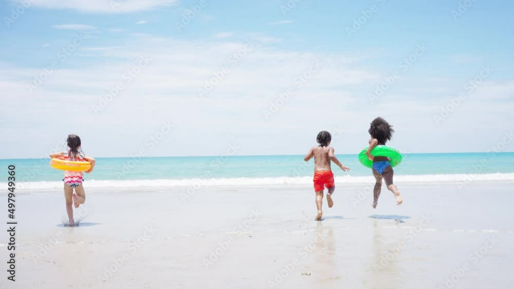 Group of Diversity little child boy and girl friends running and playing in sea water on tropical beach together on summer vacation. Happy children kid enjoy and fun outdoor lifestyle on beach holiday Group of Diversity little child boy and girl friends running and playing in sea water on tropical beach together on summer vacation. Happy children kid enjoy and fun outdoor lifestyle on beach holiday