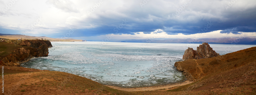 Olkhon Island on a cloudy spring day . Banner. Lake Baikal during the melting of the ice. Cape Burkhan or Shamanka Rock.