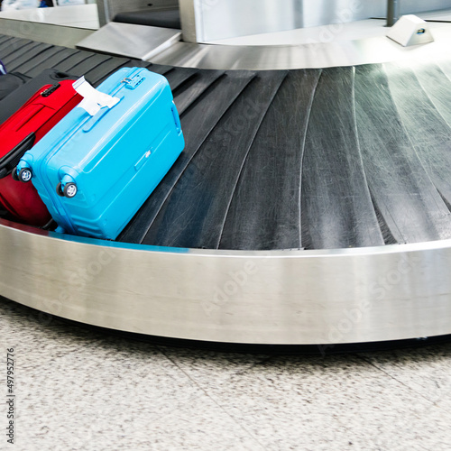 Group of suitcases on conveyor belt of airport photo