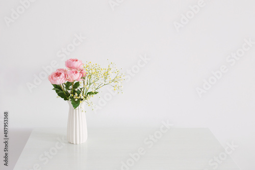 bouquet of pink roses in ceramic white vase  on white background © Siarhei