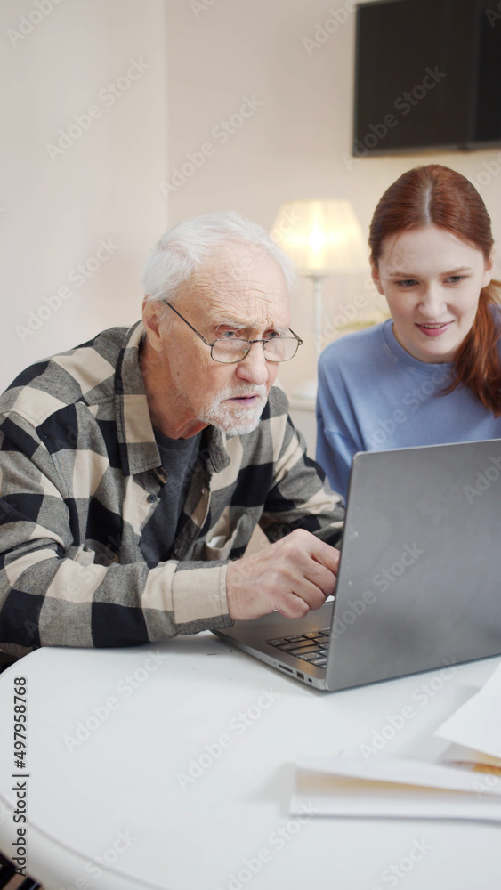 Old man learns to use computer while granddaughter helps him