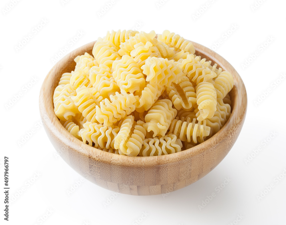 Uncooked radiatori pasta in wooden bowl isolated on white background with clipping path