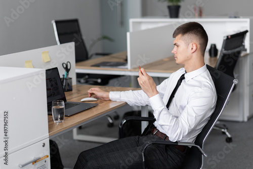 Businessman sitting at work looking at laptop. Office work concept © Olga