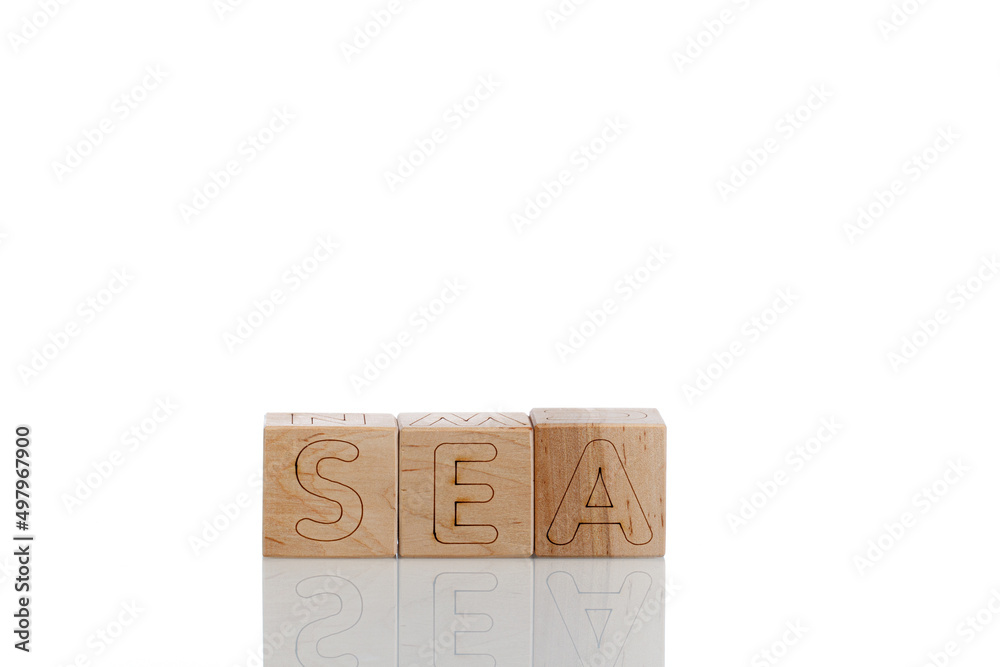 Naklejka premium Wooden cubes with letters sea on a white background