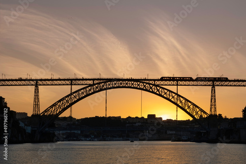 Silhouette of the train on the Ponte Luís I in sunset in Porto, Portugal © Maria