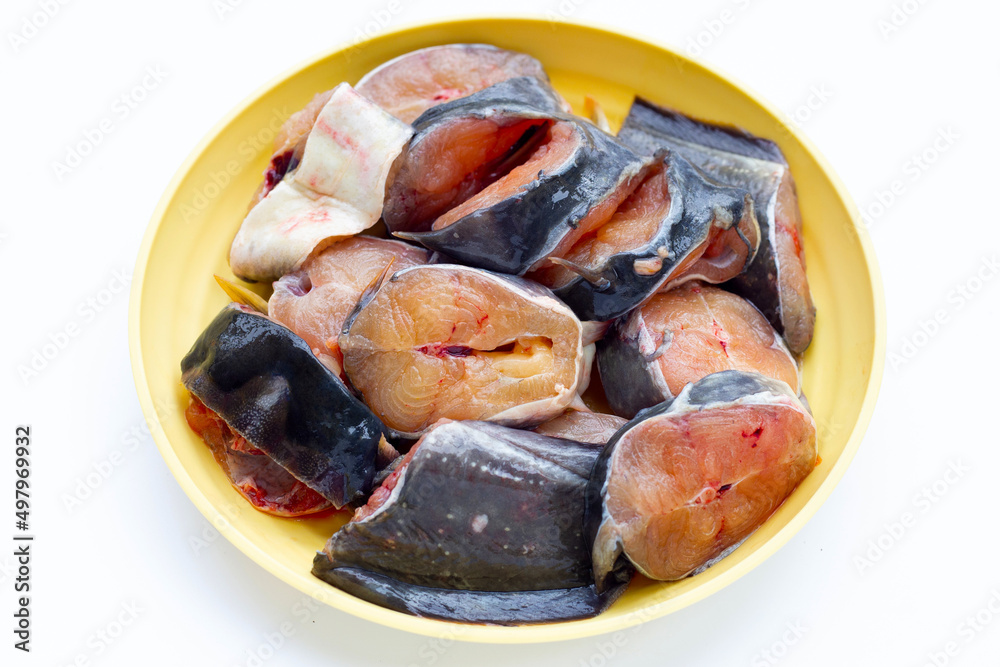 Catfish cut pieces in yellow plate on white background. Catfish cut pieces in yellow plate on white background.