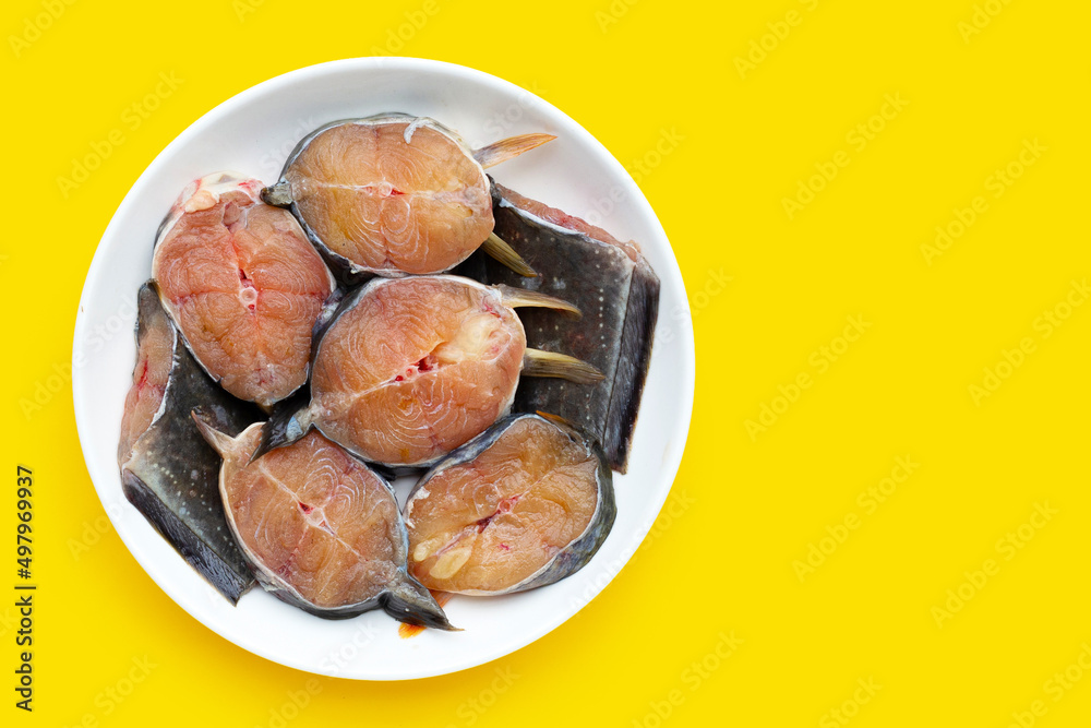 Fototapeta premium Catfish cut pieces on yellow background.