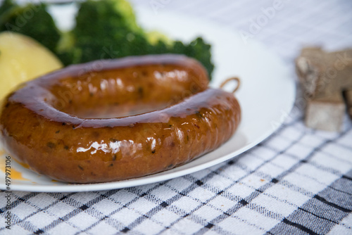 Fototapeta Naklejka Na Ścianę i Meble -  Alheira, a typical dish of Portuguese gastronomy made of pork accompanied by broccoli and boiled potatoes drizzled in olive oil. Typical meal and much appreciated in the coldest season of the year.