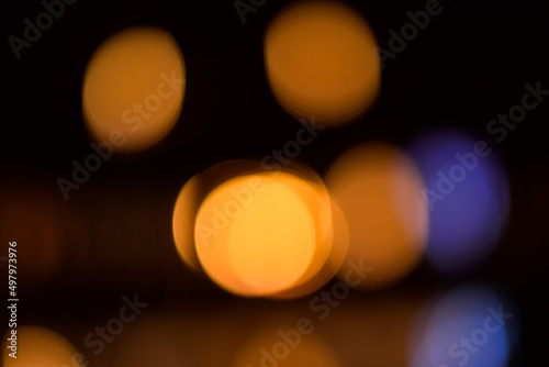 Art photo with orange and lilac circles of light in the side. Focal blurring of light in the form of a game of colored spots. © Aleksandr