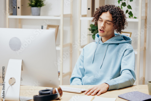 handsome guy sitting at a table in front of a computer freelance interior