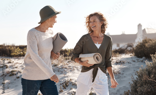 Loving life on the beach. Cropped shot of two attractive mature woman walking with their on the beach. photo