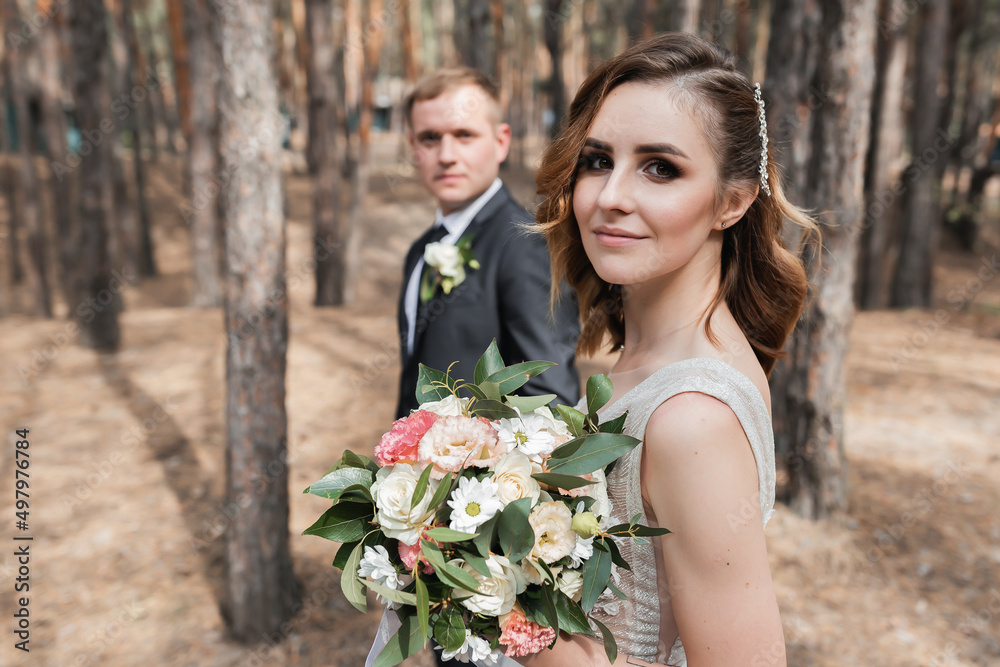 Wedding couple in the park. An elegant bride of European appearance and a groom in a black suit. Wedding couple in the park. An elegant bride of European appearance and a groom in a black suit.