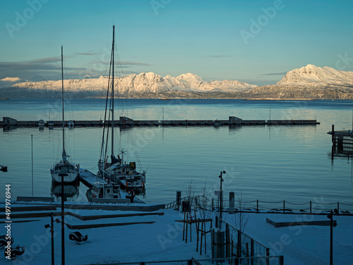 Sailing boats moored at Harstad, Norway, with snow capped mountains photo