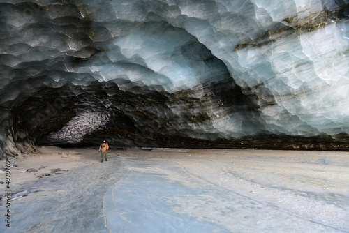 A hiker explores an ice cave in Alaska's Castner Glacier.