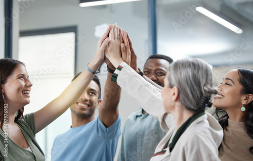 We promise to always support each other. Shot of a group of businesspeople giving each other a high five in an office.