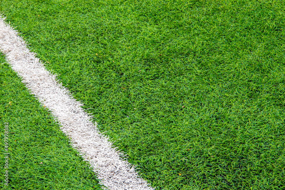 Fototapeta premium white markings on the artificial turf of a football field, desktop background, soft blur