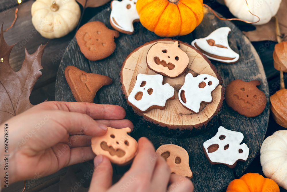 Homemade halloween holiday treats for kids. Gingerbread cookies on wooden board, decorated with pumpkins and autumn leaves. Top view