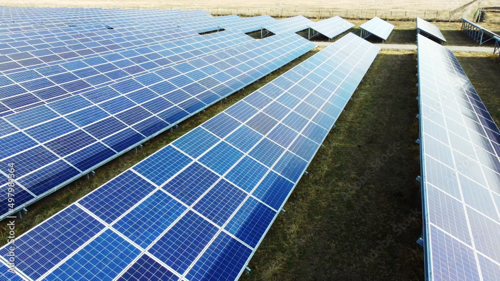 Aerial drone view flight over solar power station panels. Aerial top view of solar farm. Green energy, electrical innovation. Renewable Energy. Industrial Solar Energy Farm producing solar power. Aerial drone view flight over solar power station panels. Aerial top view of solar farm. Green energy, electrical innovation. Renewable Energy. Industrial Solar Energy Farm producing solar power.