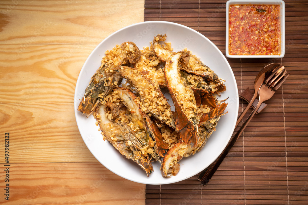 Stir fried flathead lobster with garlic and pepper on wooden table, Fried flathead lobster with garlic. Stir fried flathead lobster with garlic and pepper on wooden table, Fried flathead lobster with garlic.