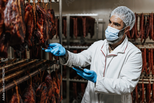 Canvas-taulu Experienced middle age man working in fresh meat processing plant