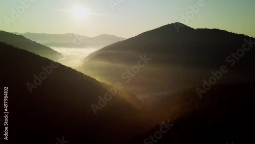 Mountain peaks and morning sky with smooth moving clouds. Summer landscape paeceful valley trees in the meadow at Carpathian mountains. Ukraine. photo